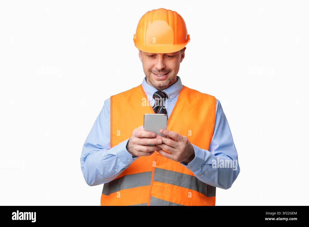 Construction Worker Using Smartphone Standing On White Studio Background Stock Photo