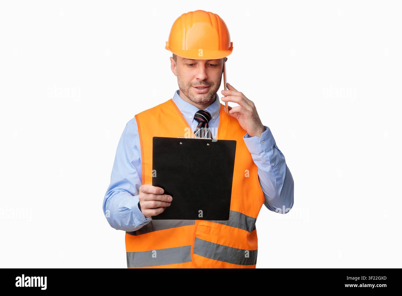 Repairman Worker Talking On Cellphone Holding Folder Standing In Studio Stock Photo