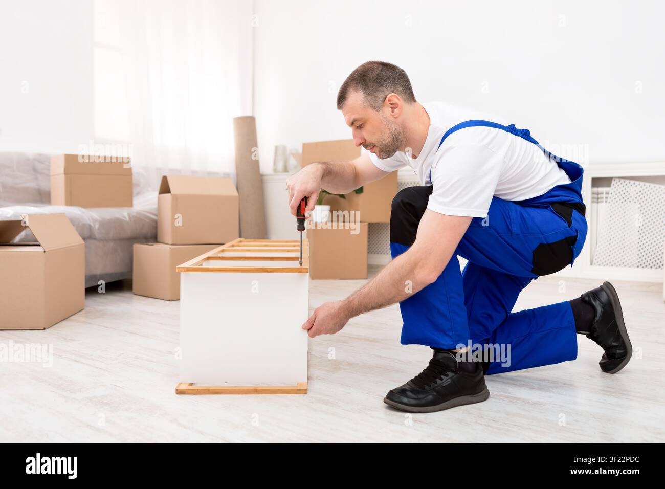 Repair Worker Installing Shelf Using Screwdriver Working Indoors Stock Photo