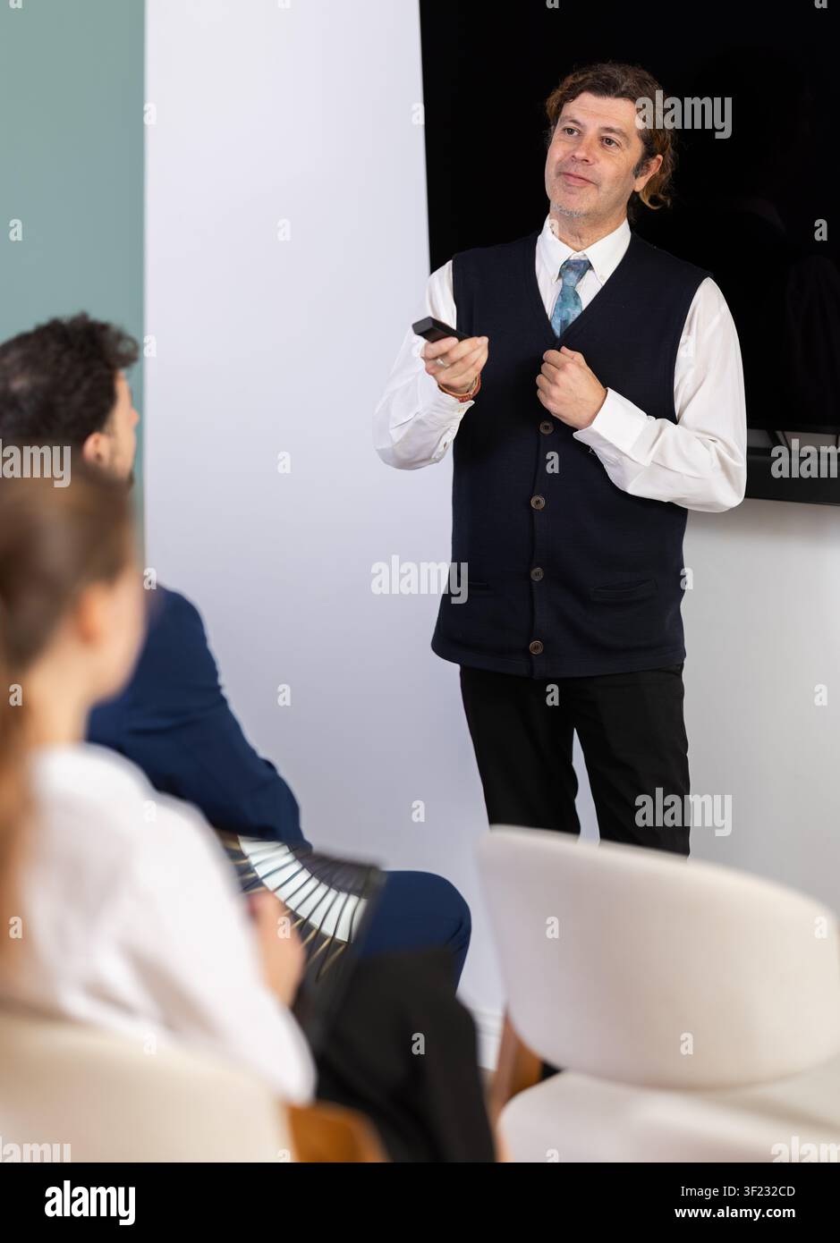 Male business trainer explaining topic to professionals using digital board Stock Photo