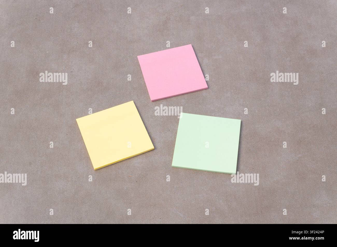 Three blank sticky notes are scattered on a background, representing planning, organization, and communication Stock Photo
