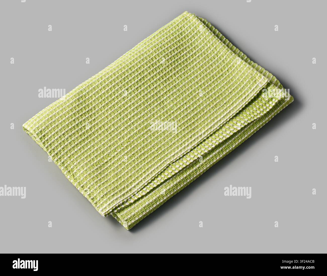 folded green dish towel isolated gray background, textured white striped pattern cleaning cloth, angle view Stock Photo