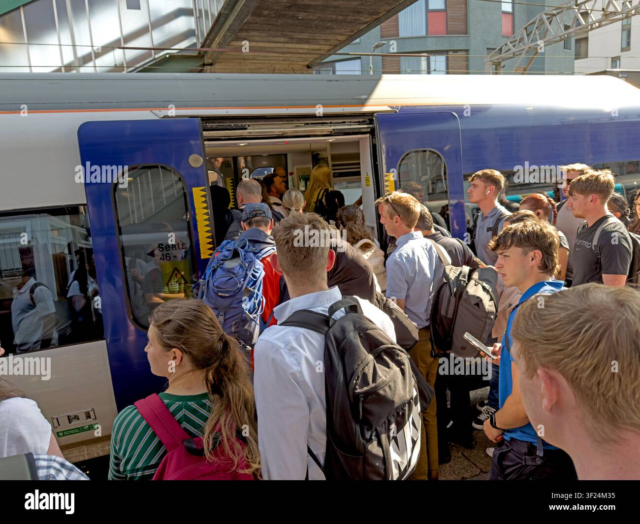 Open carriage door and a crowded platform at Manchester Oxford Road station during a summer evening commuter rush in the city centre Stock Photo