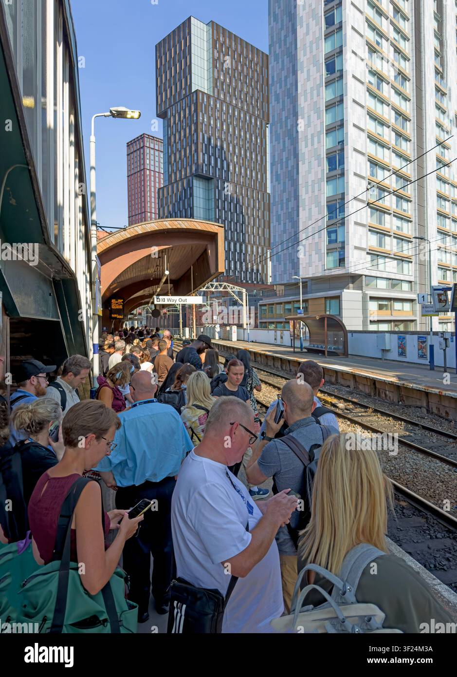 Evening passengers crowd a narrow platform at Manchester Oxford Road railway station in the busy city-centre Castlefield Corridor. Stock Photo