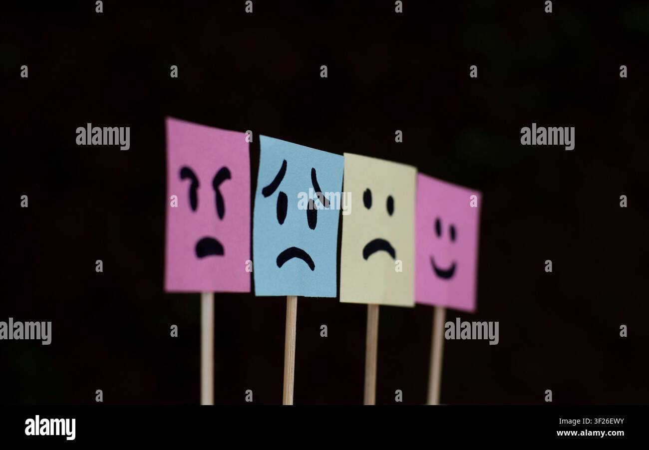 Four Colorful Mood Face Notes on Dark Background Stock Photo