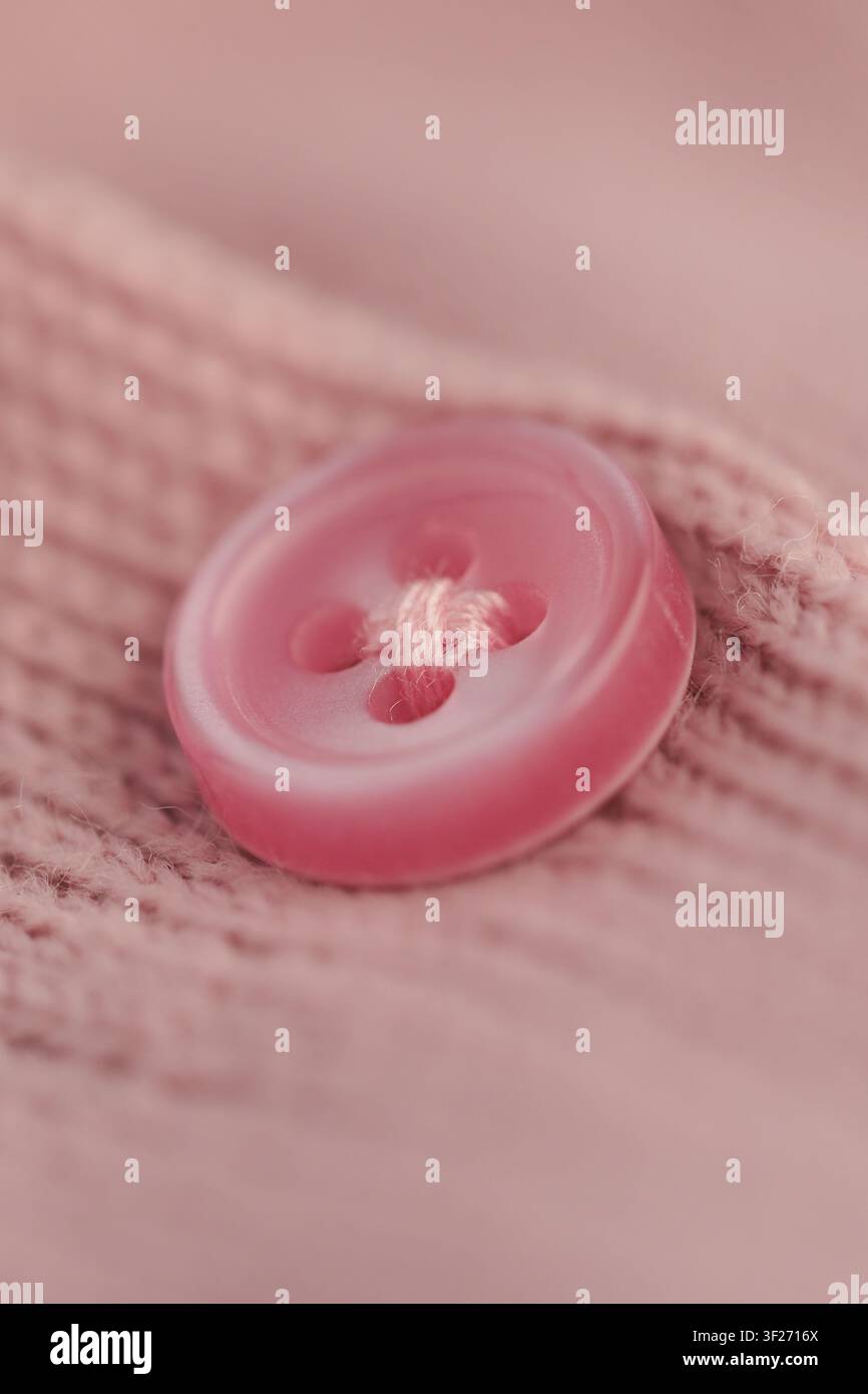 Bright pink button on soft fabric in close up view Stock Photo