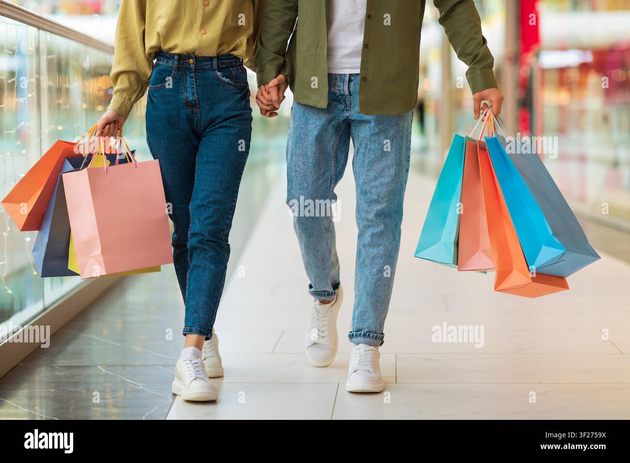 Couple Holding Shopping Bags Walking Together In Mall, Shopping Lifestyle Concept Stock Photo