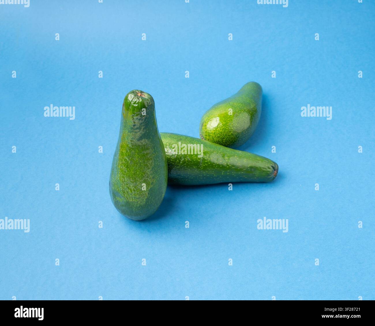 Avocado Isolated, Whole Avokado Set, Three Green Avocados Pile, Fresh Alligator Pear, Guacamole Ingredient, Long Avocado Fruit on Blue Background Stock Photo