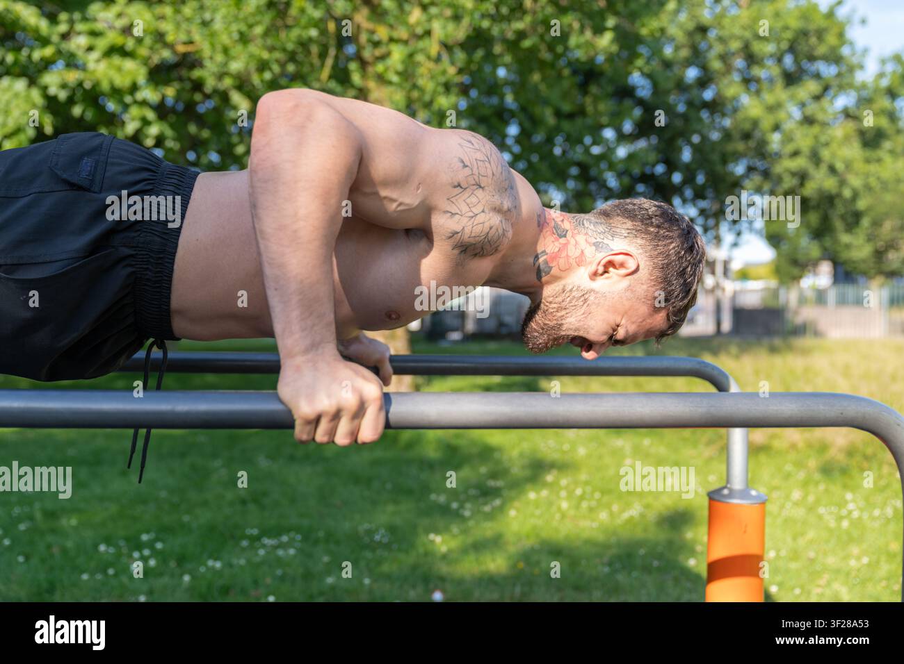 Man doing calisthenics push ups outdoor training Stock Photo