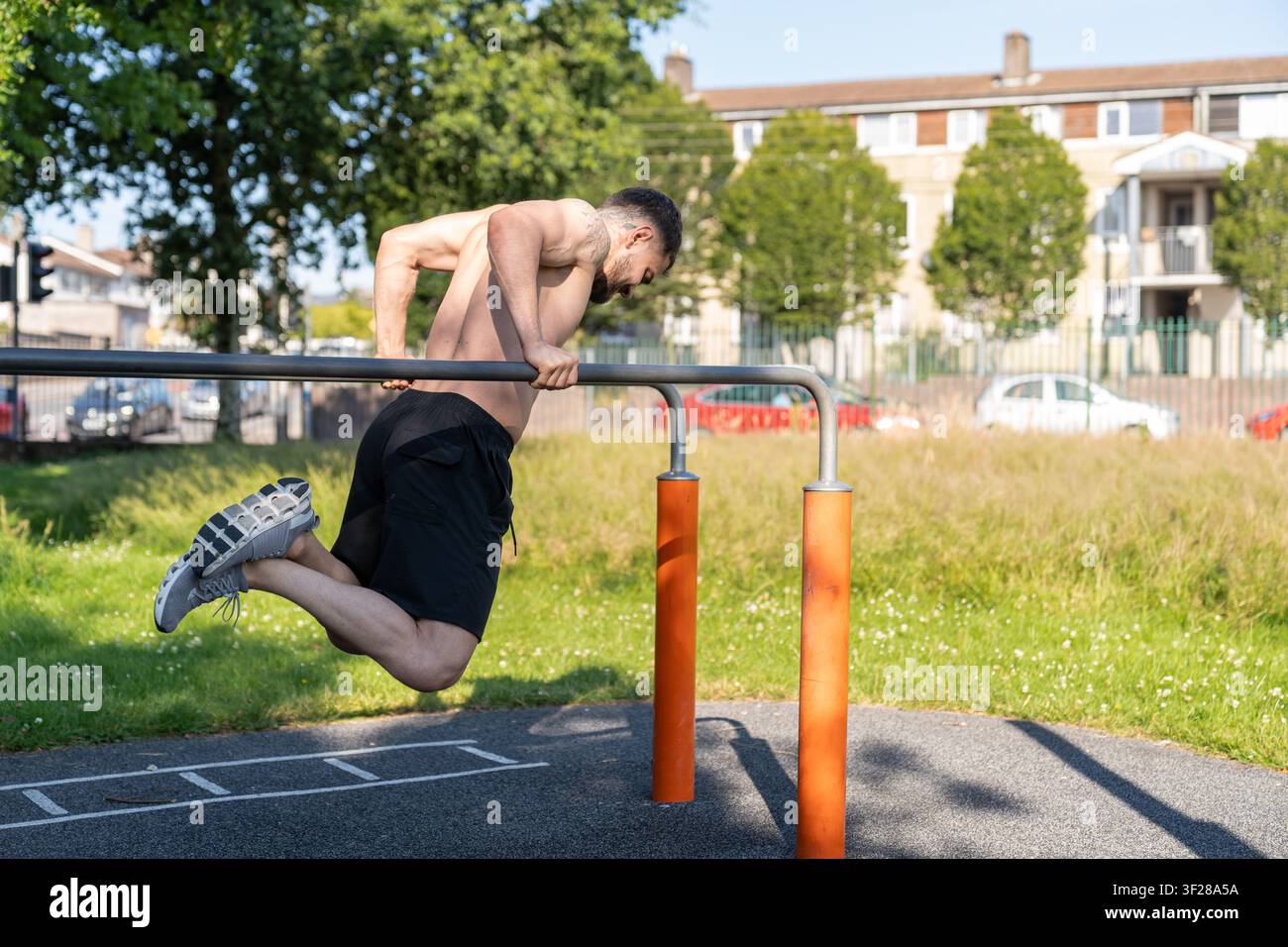Man doing calisthenics tricep dips on parallel bars Stock Photo
