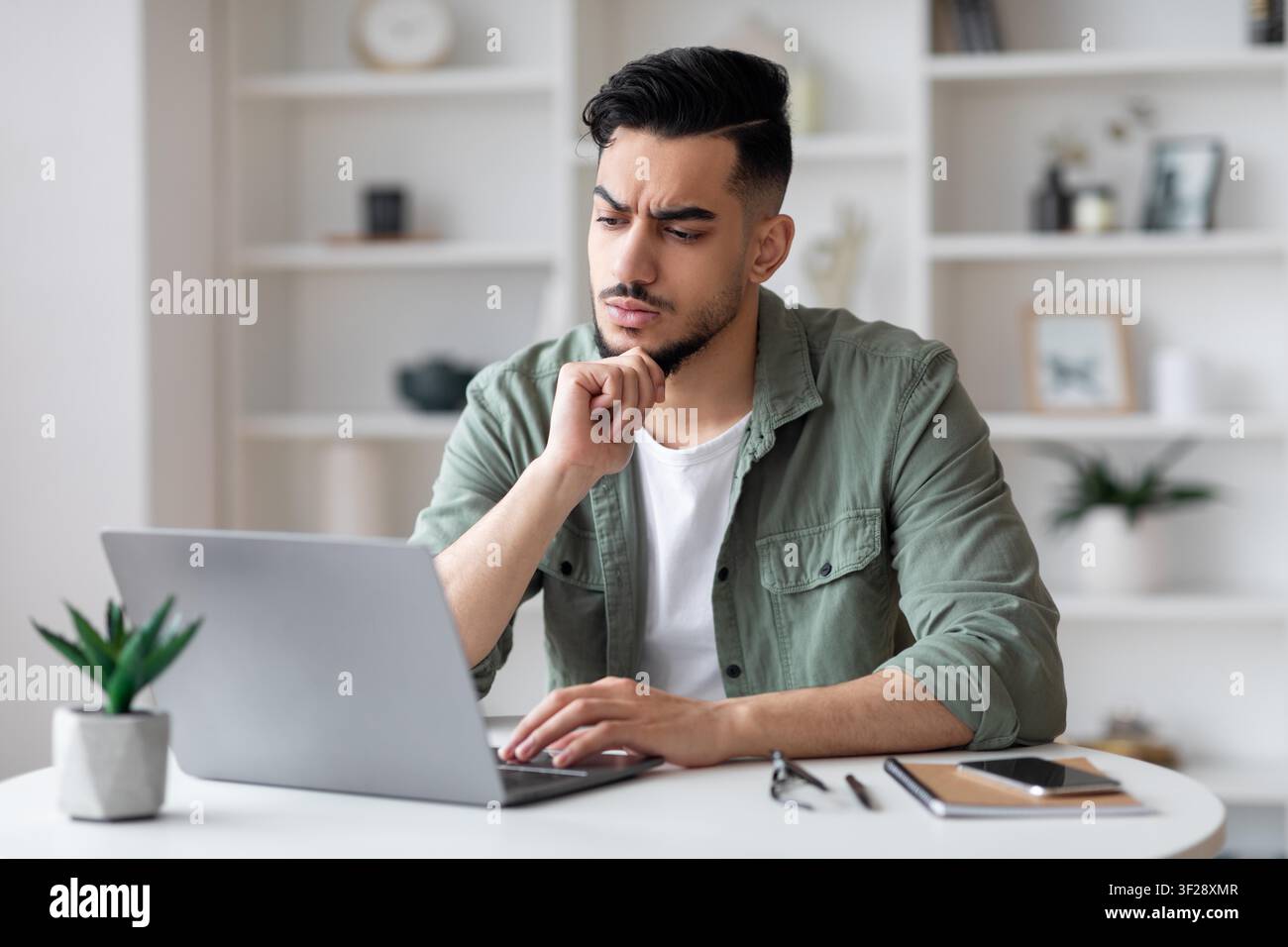 Focused Young Man Working On Laptop In Office, Weight Loss Concept Stock Photo