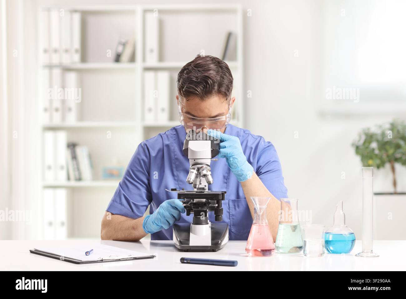 Laboratory technician looking through a microscope Stock Photo