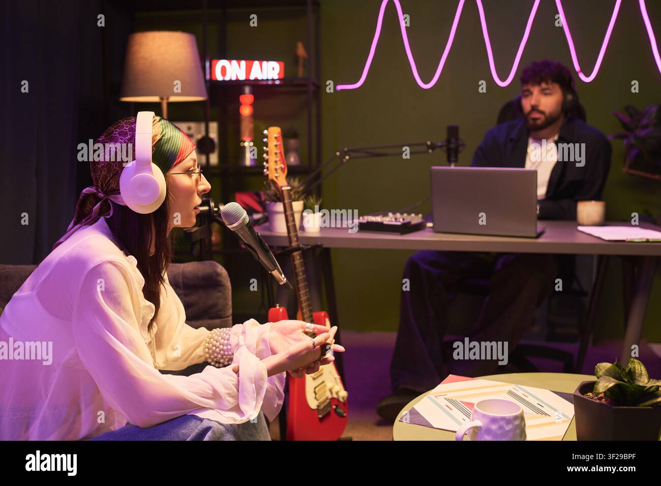 Young Woman Recording Podcast Interview in Creative Studio Stock Photo