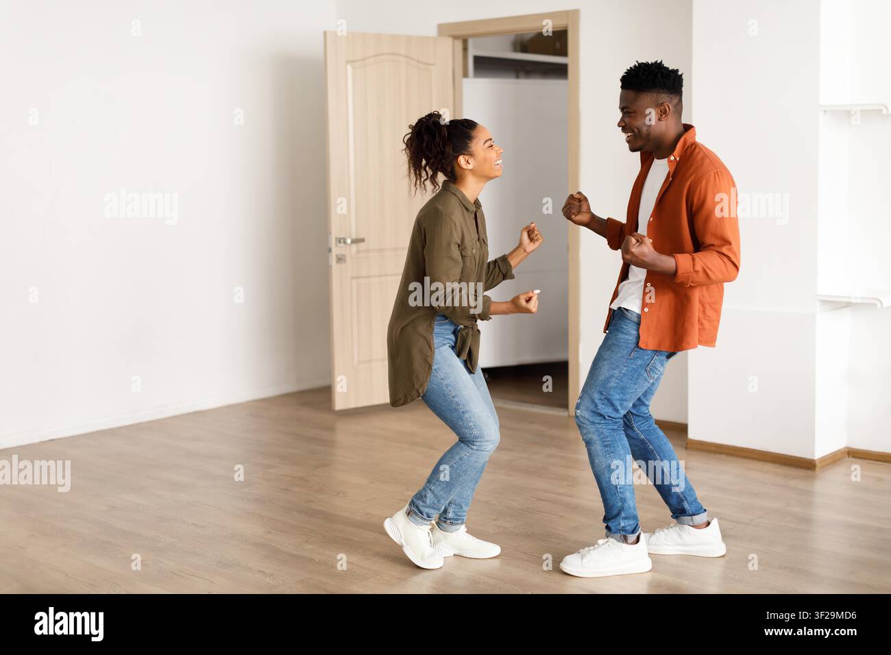 Happy Black Couple Dancing Together In New Apartment, Joyful Moment Stock Photo