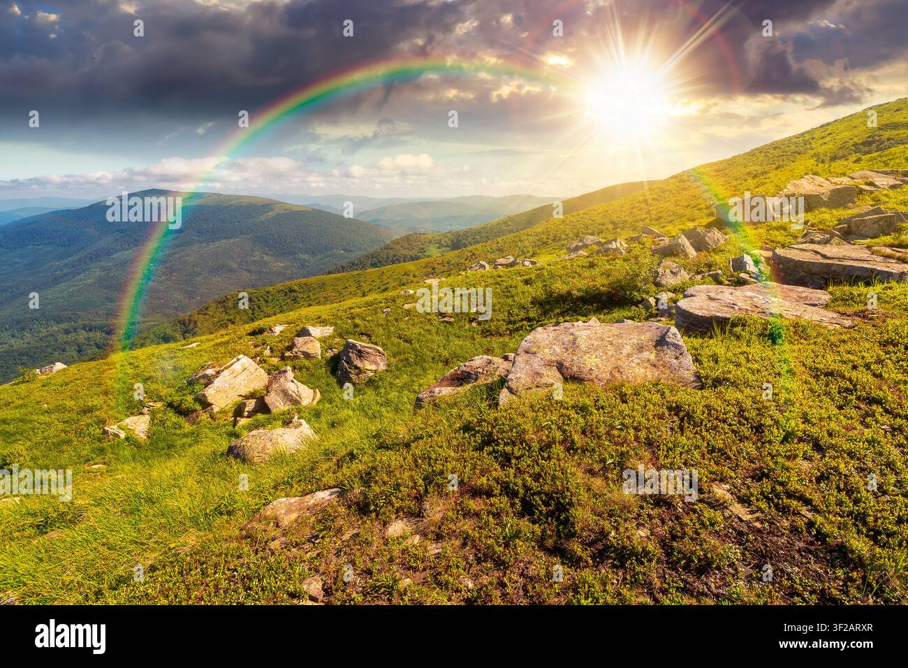 sunset over mountain landscape with grass and rock on a slope. view in to the distant valley of carpathian mountains. mountainous scenery of ukraine i Stock Photo