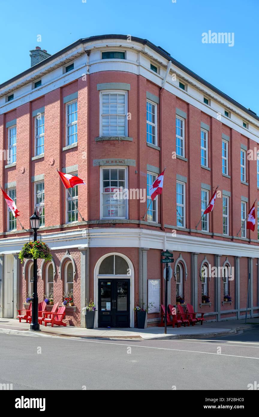 Historic corner brick building with Canadian flags and preserved heritage architecture. Stock Photo