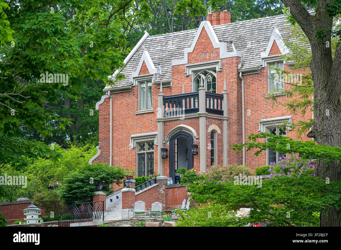 Historic brick mansion with landscaped gardens and mature trees. Stock Photo