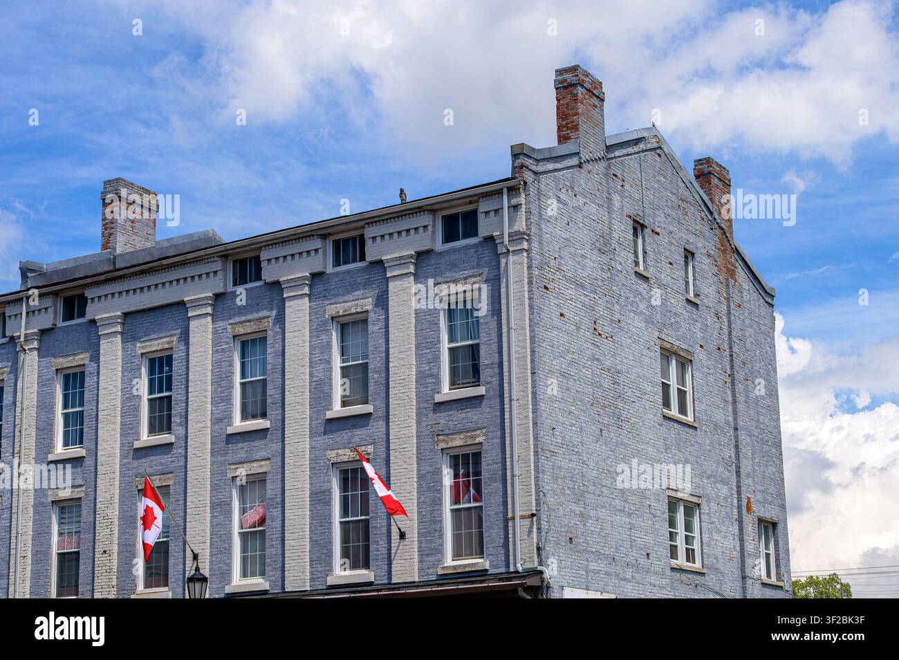 Colonial brick building with Canadian flags, old architecture is common in the small town Stock Photo