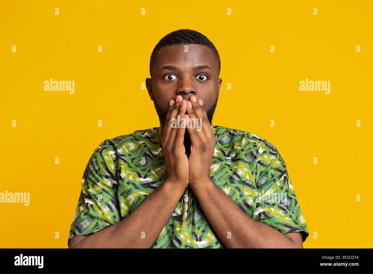 Shocked black man covering mouth with hands Stock Photo