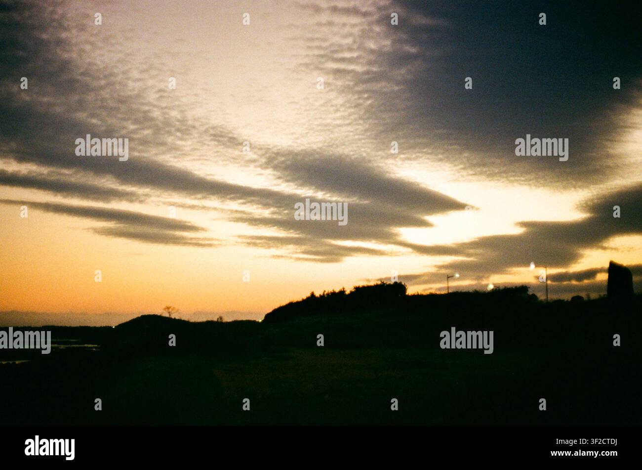 Dramatic Sunset Over a Rural Landscape With Dark Clouds Stock Photo