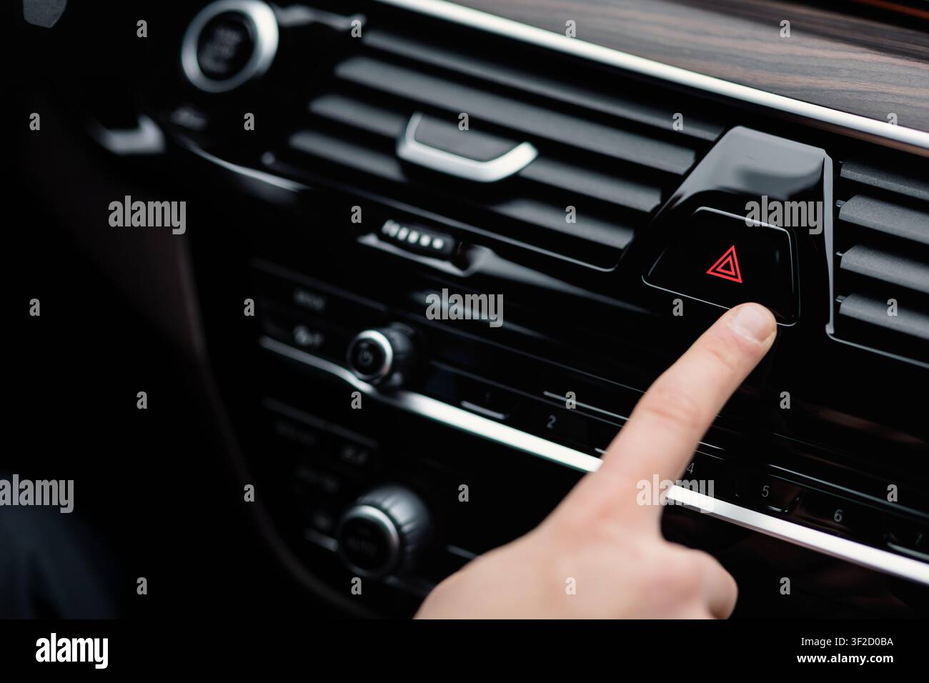 Man pressing red triangle car hazard light button Stock Photo