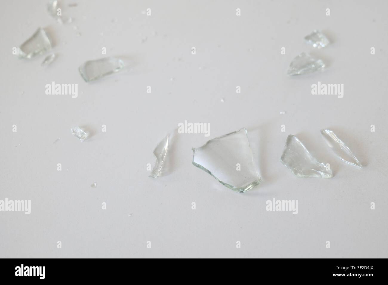 Broken Glass Shards on White Tile Surface Stock Photo