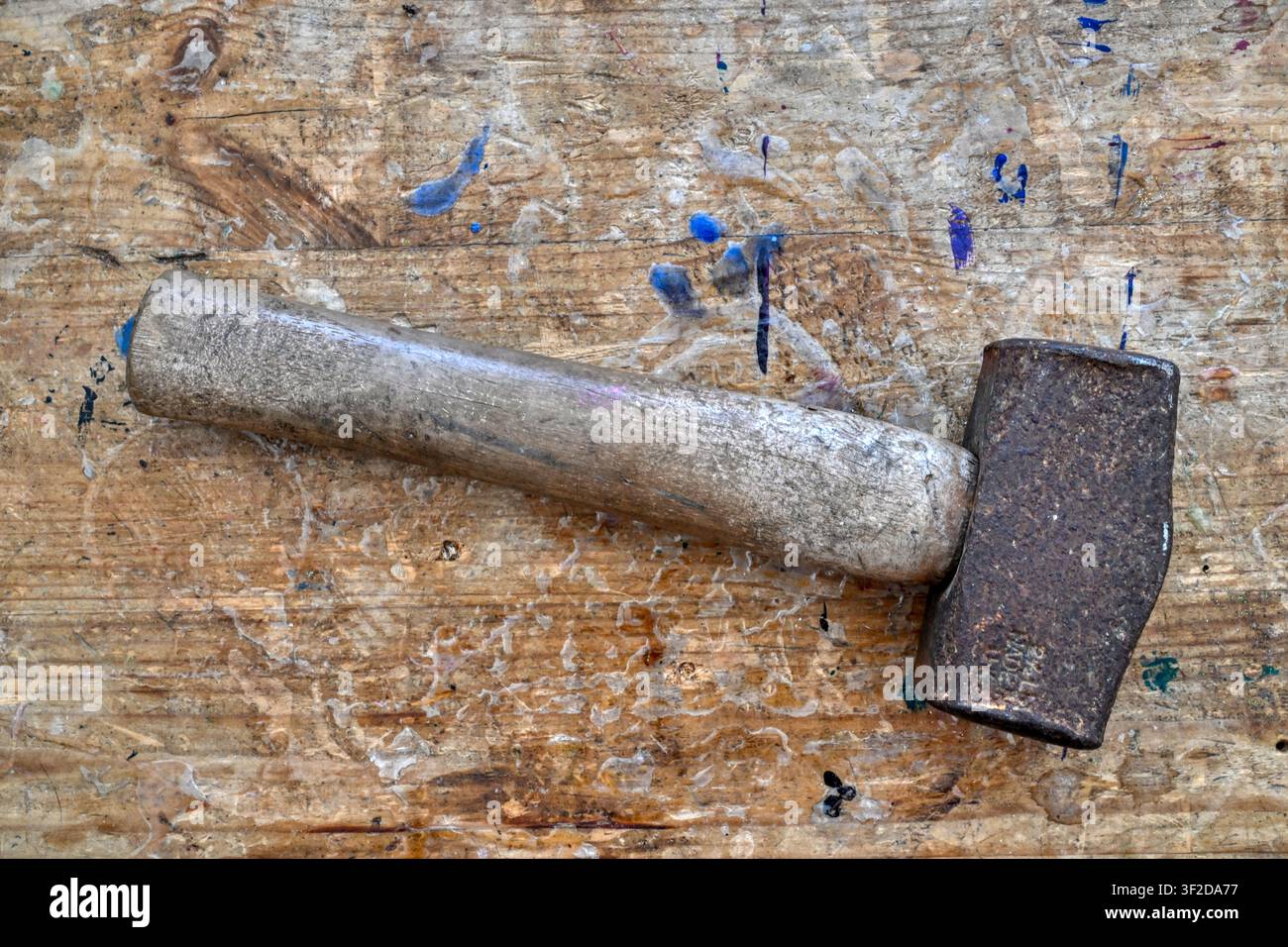 Rusty old mallet on weathered wooden workbench top Stock Photo