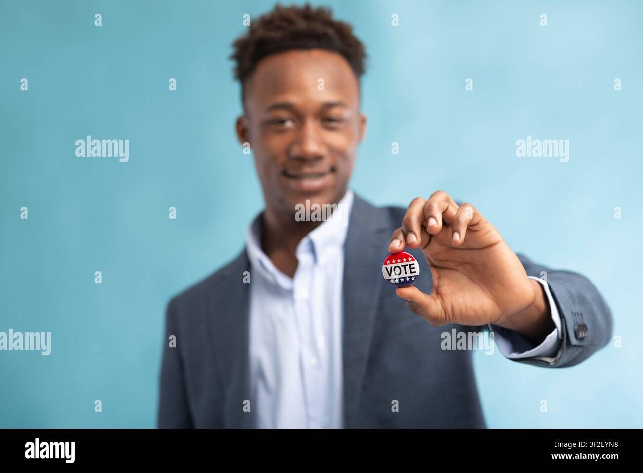 African american Man with Vote button on blue Stock Photo