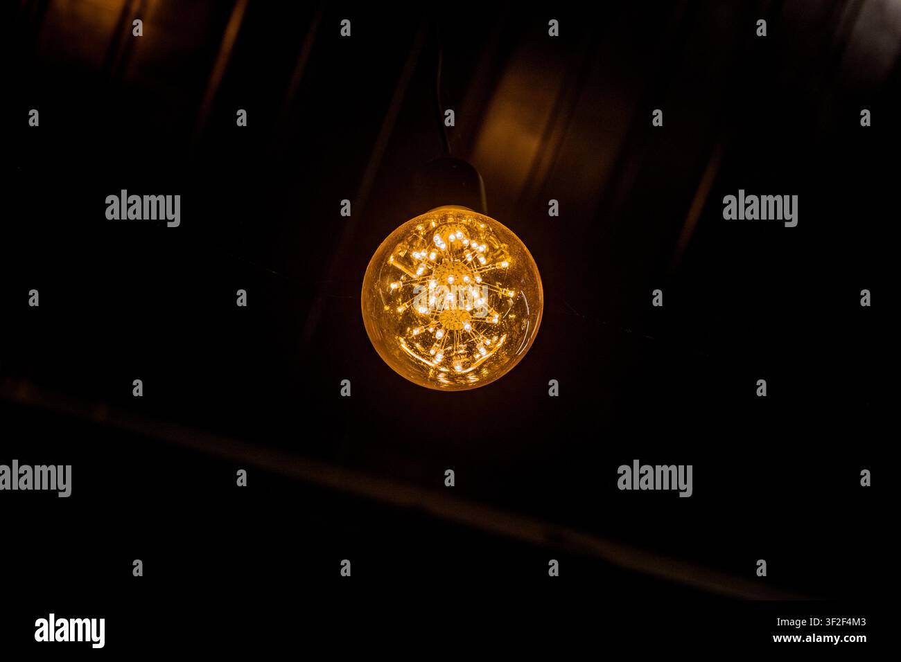 Glowing Edison Light Bulb in the Dark Stock Photo