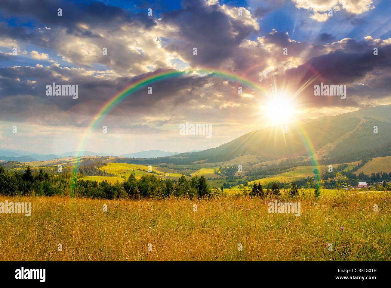 sunset over countryside mountain landscape in summer. lush grassy pasture on a hill near forest. rural outdoor adventure background. alpine highland o Stock Photo