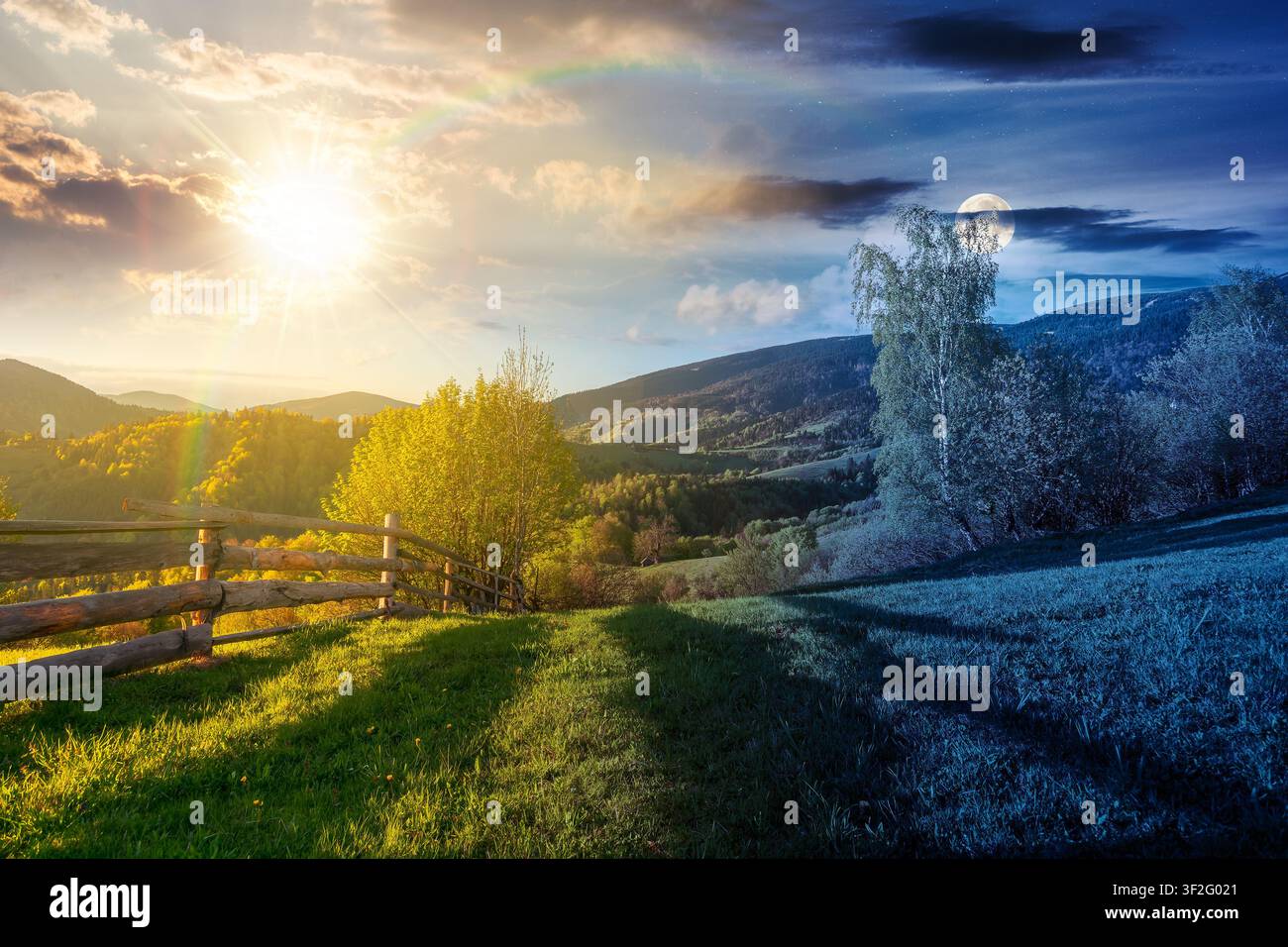 day meet night in mountainous rural landscape in spring. epic view of valley fields at twilight. sun and moon over alpine meadow. carpathian mountains Stock Photo