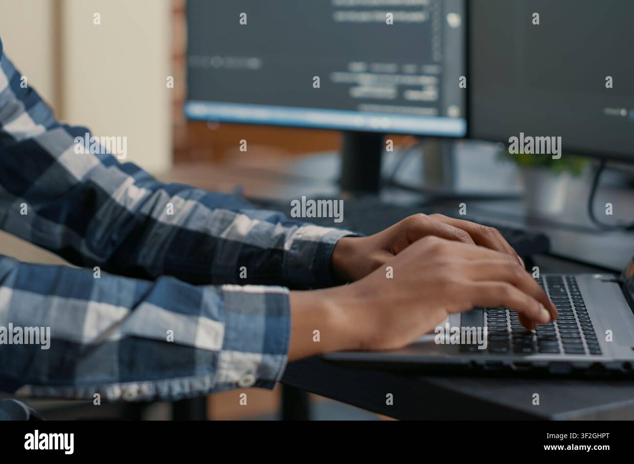 Programmer Typing Machine Learning Code on Laptop in a software development office, showing programmers collaborating on source code, algorithms and data coding workflow. Stock Photo