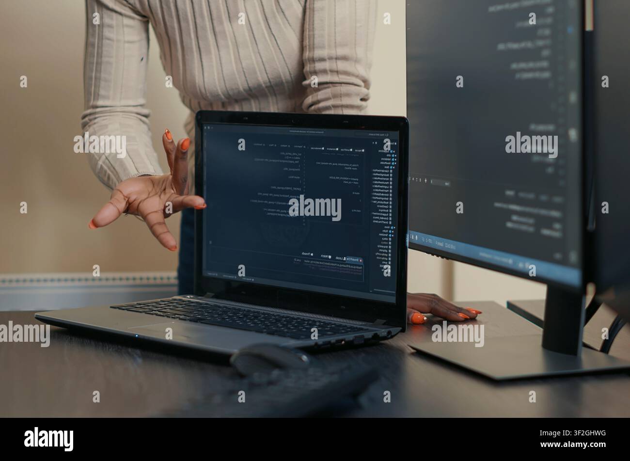 Laptop Compiling Algorithm Beside Developer Team in a software development office, showing programmers collaborating on source code, algorithms and data coding workflow. Stock Photo