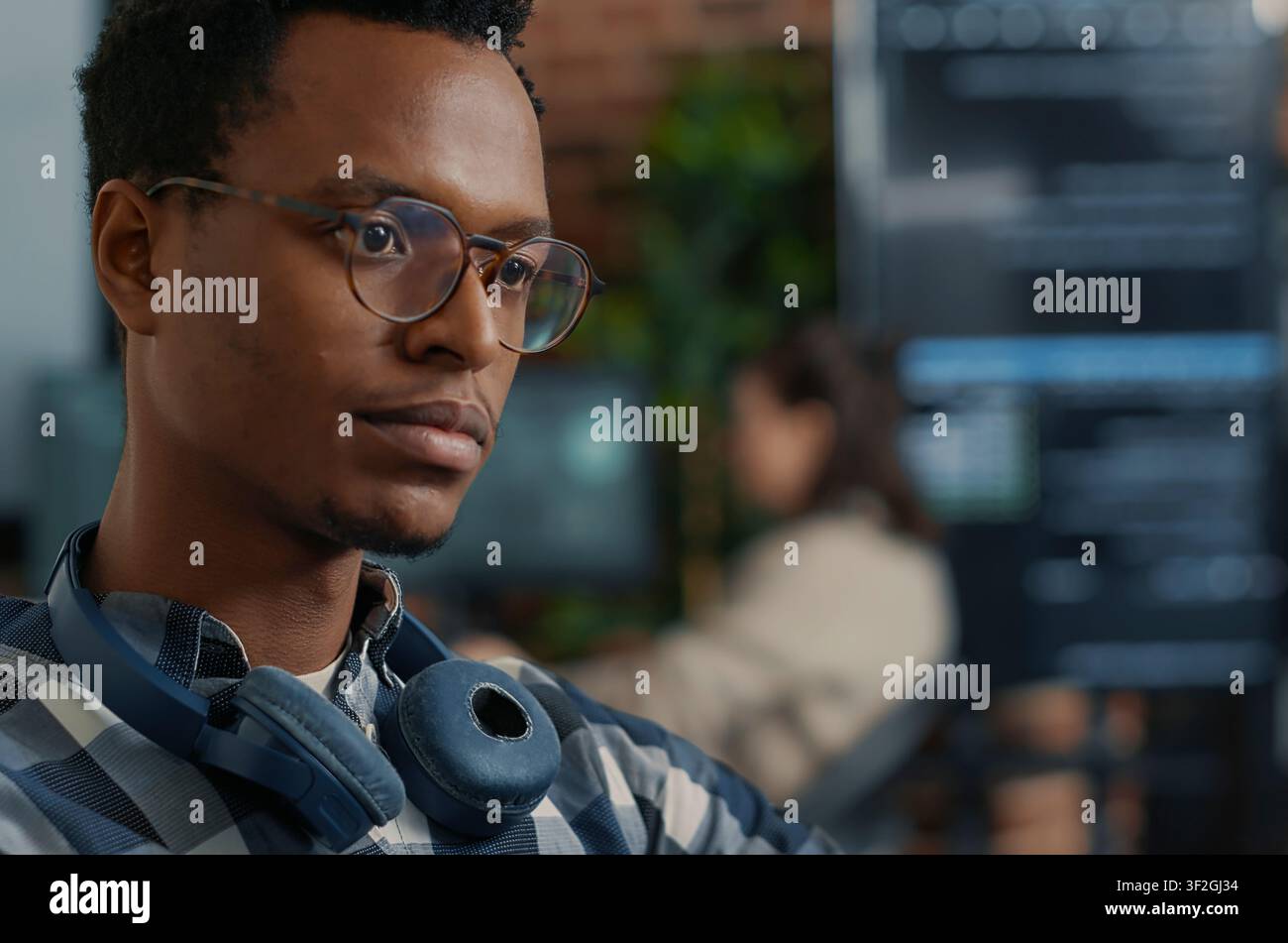 Software Engineer Fixing Glasses While Coding at a software development desk after compiling source code successfully, showing algorithm work and coding success. Stock Photo