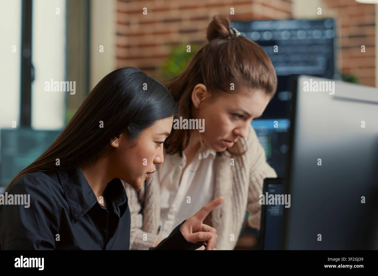 Software Engineers Discussing Source Code on Laptop in a software development office, showing programmers collaborating on source code, algorithms and data coding workflow. Stock Photo
