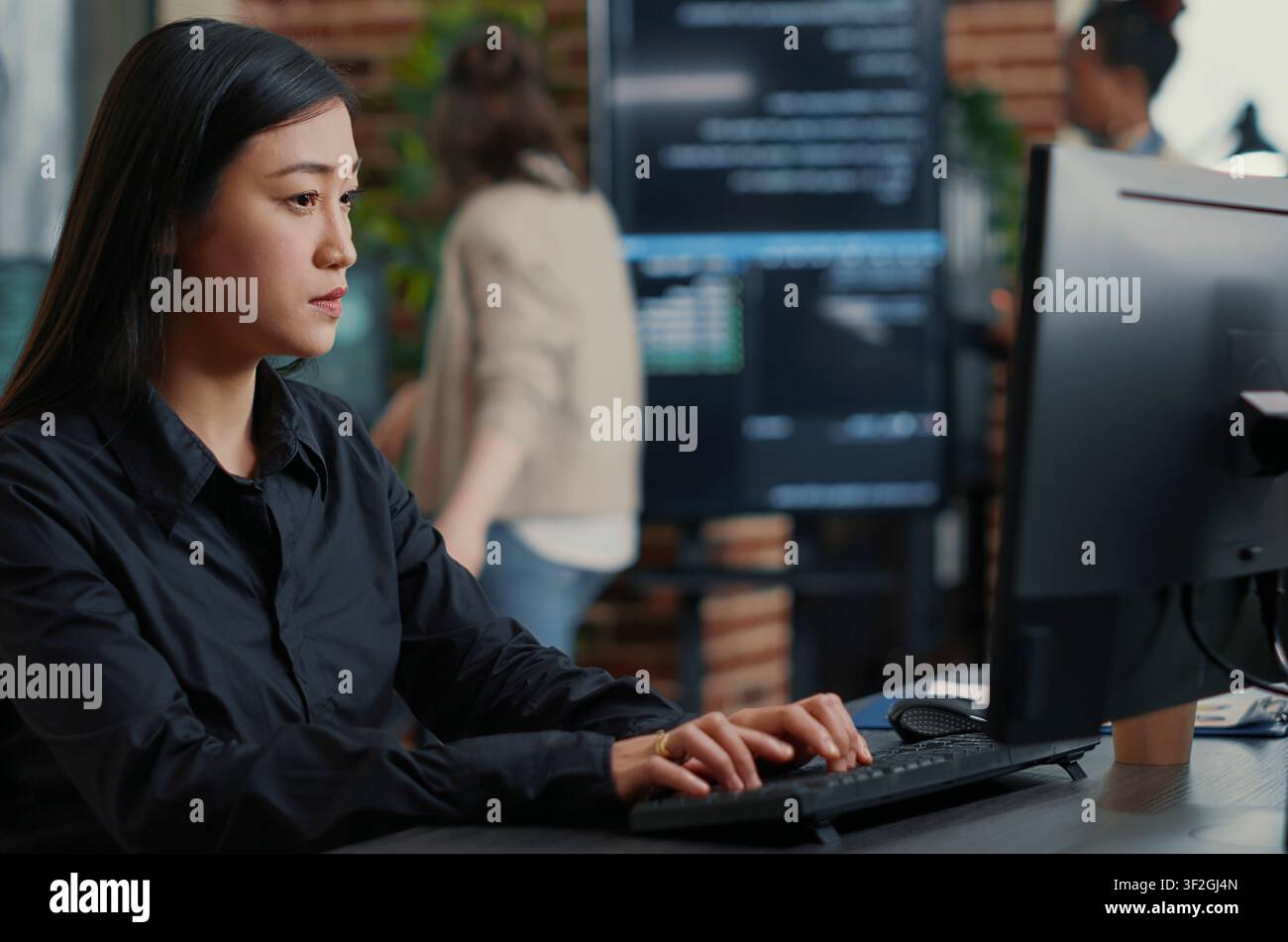 Programmer Compiling Algorithm with Team Behind in a software development office, showing programmers collaborating on source code, algorithms and data coding workflow. Stock Photo