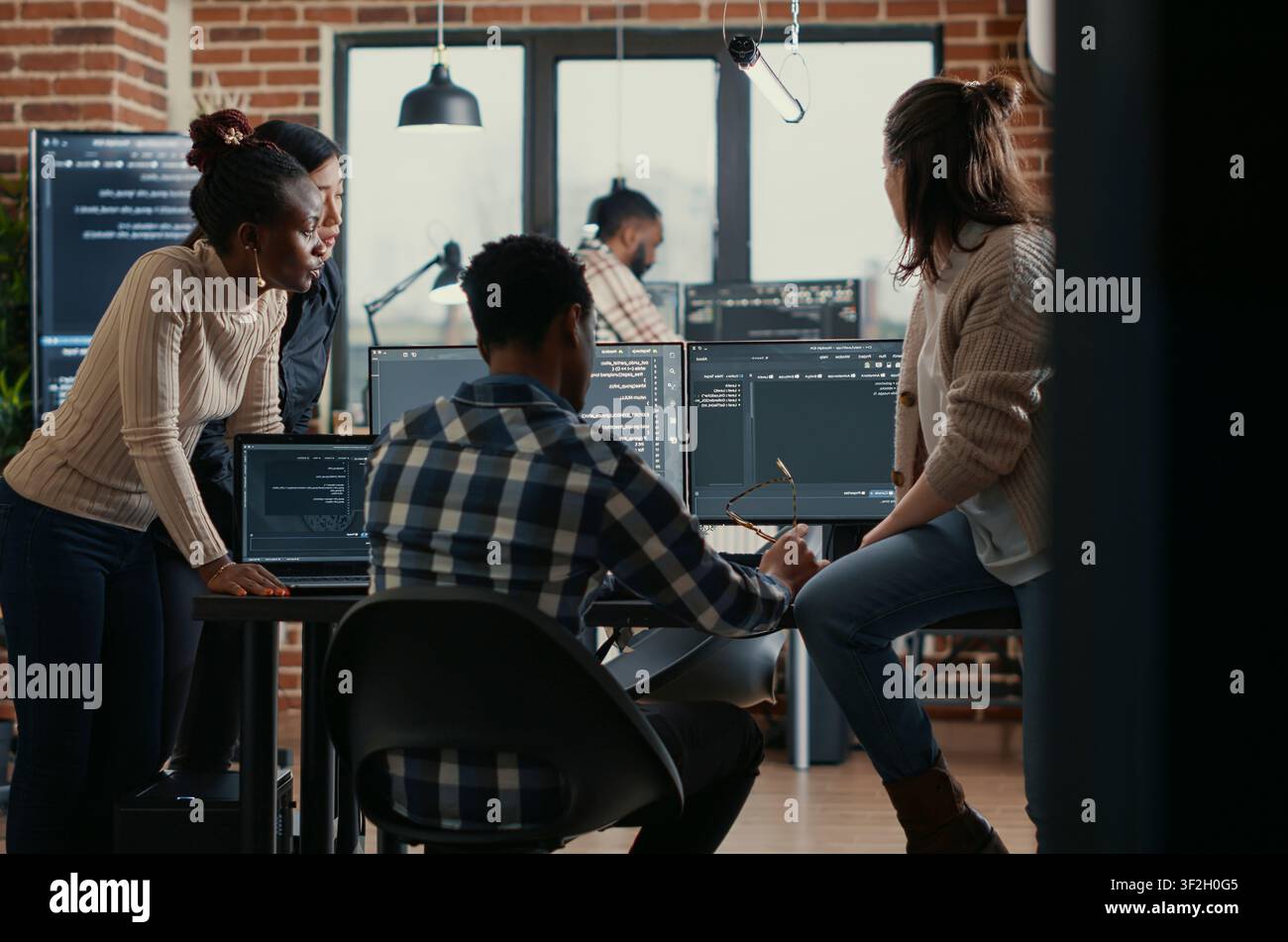 Software programmers discussing about online cloud computing while the rest of the team joins in front of multiple screens compiling code, coders doing teamwork looking at running algorithms. Stock Photo