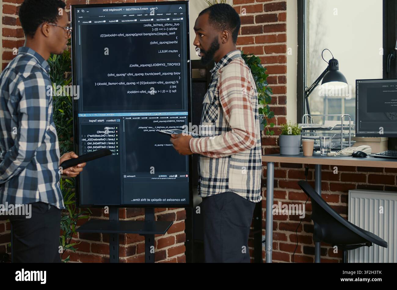 Software engineers leaving after source code analysis in a software office, showing source code, programming workflow and technical collaboration on digital development tasks. Stock Photo