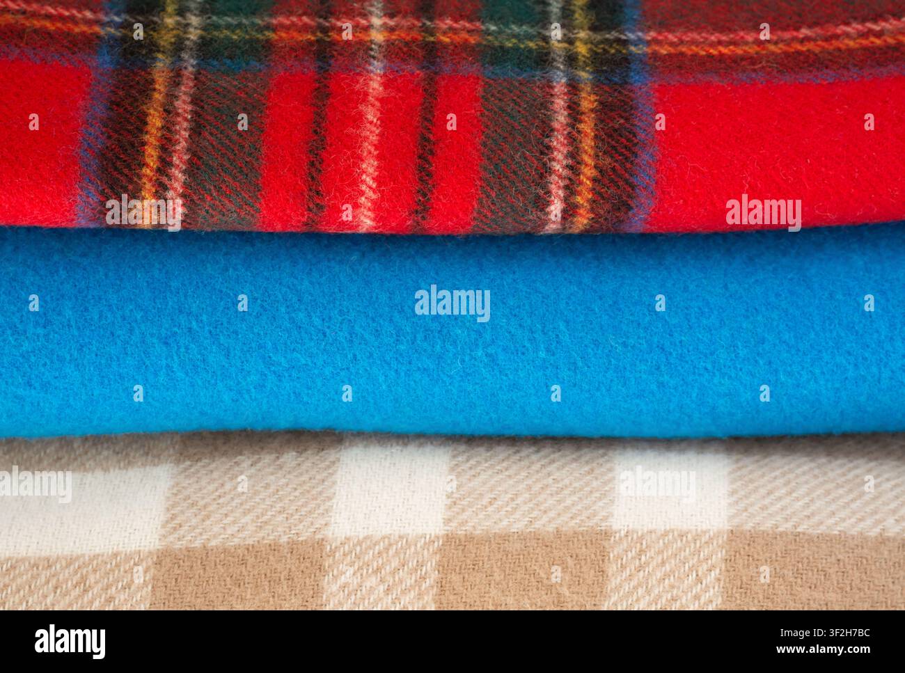 Folded warm scarves: checkered beige, checkered red and blue Stock Photo