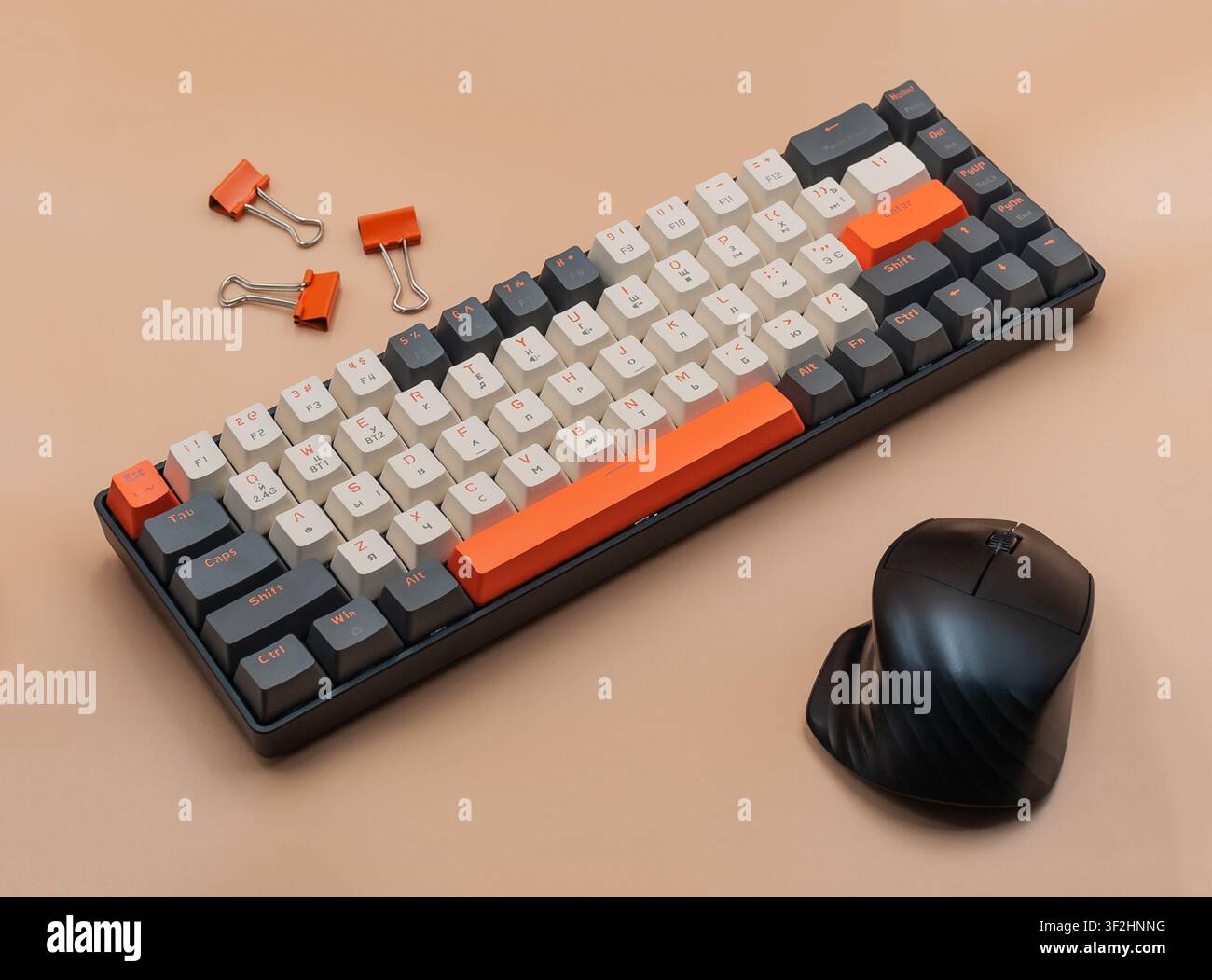 Mechanical keyboard with computer mouse and binder clips on beige background Stock Photo