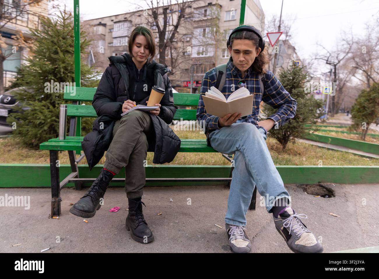 Two students studying together on park bench Stock Photo