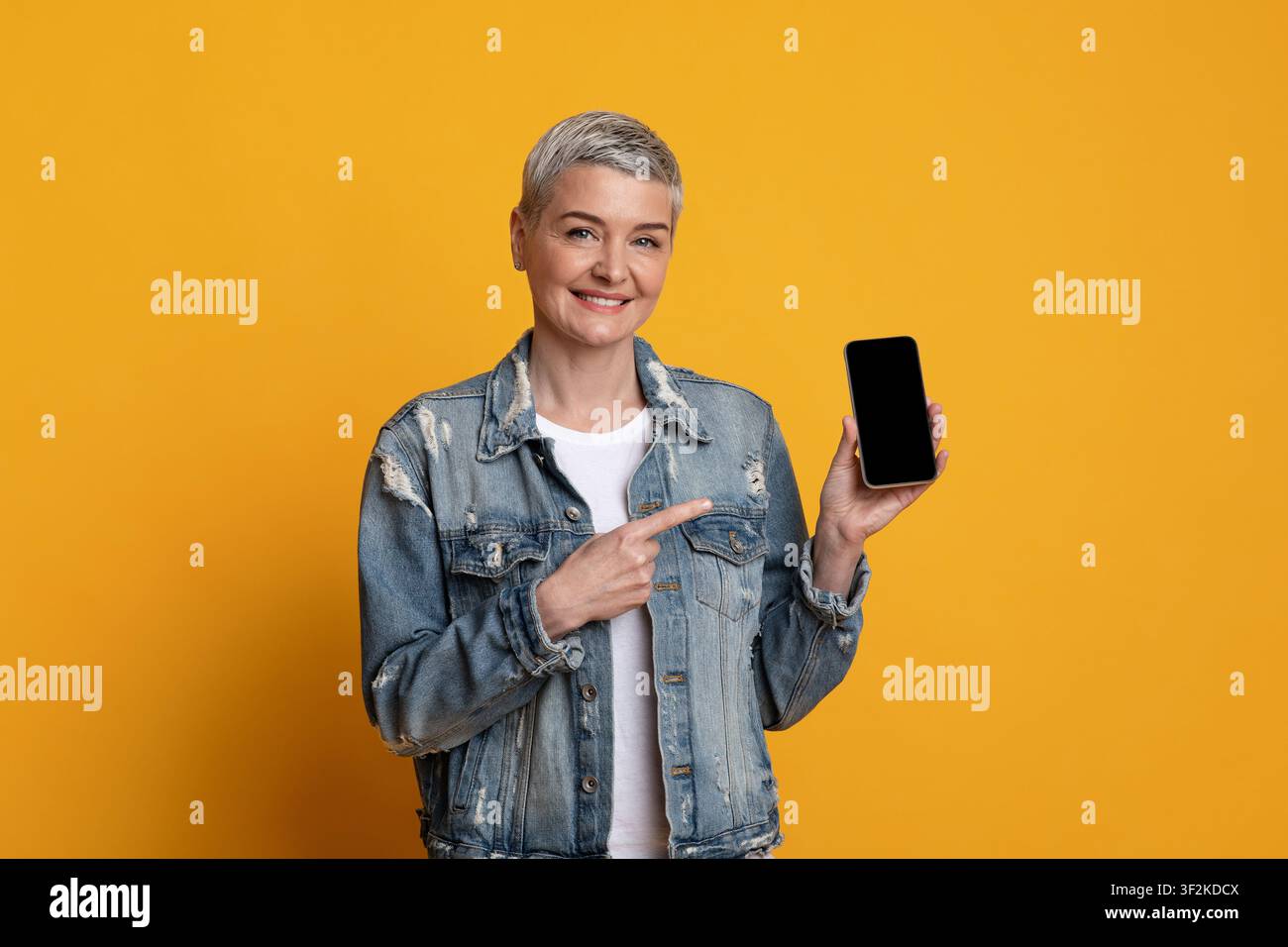 Great App. Smiling Mature Lady Pointing At Smartphone With Black Screen Stock Photo