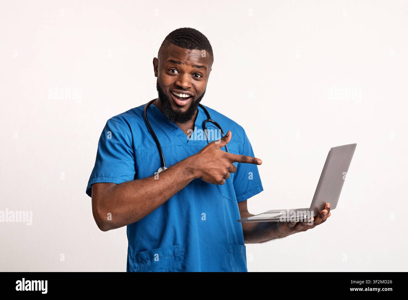 Emotional black doctor holding laptop over white background Stock Photo