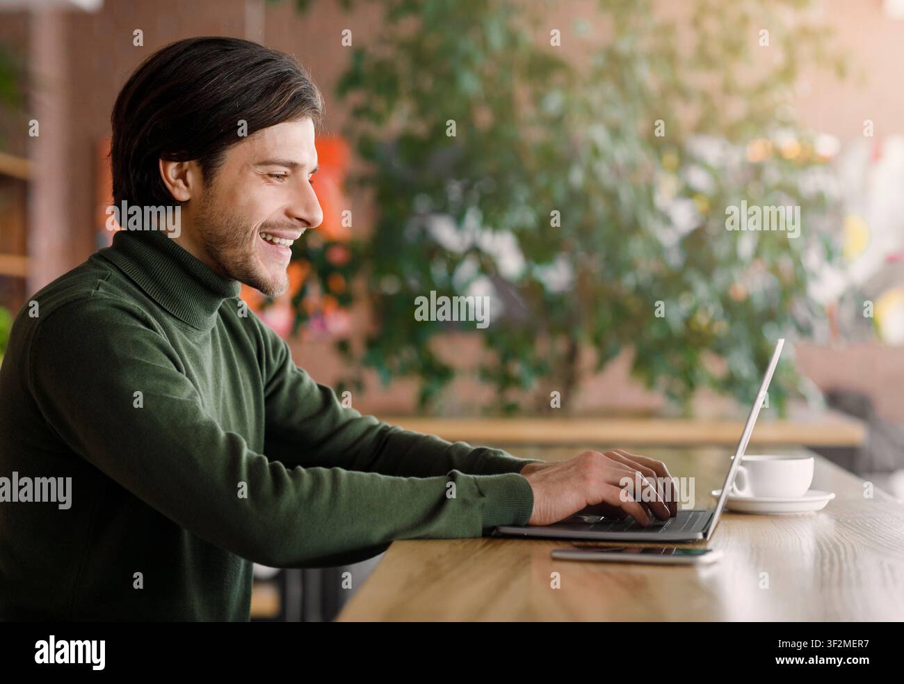 Successful web-designer working at cafe, using laptop Stock Photo