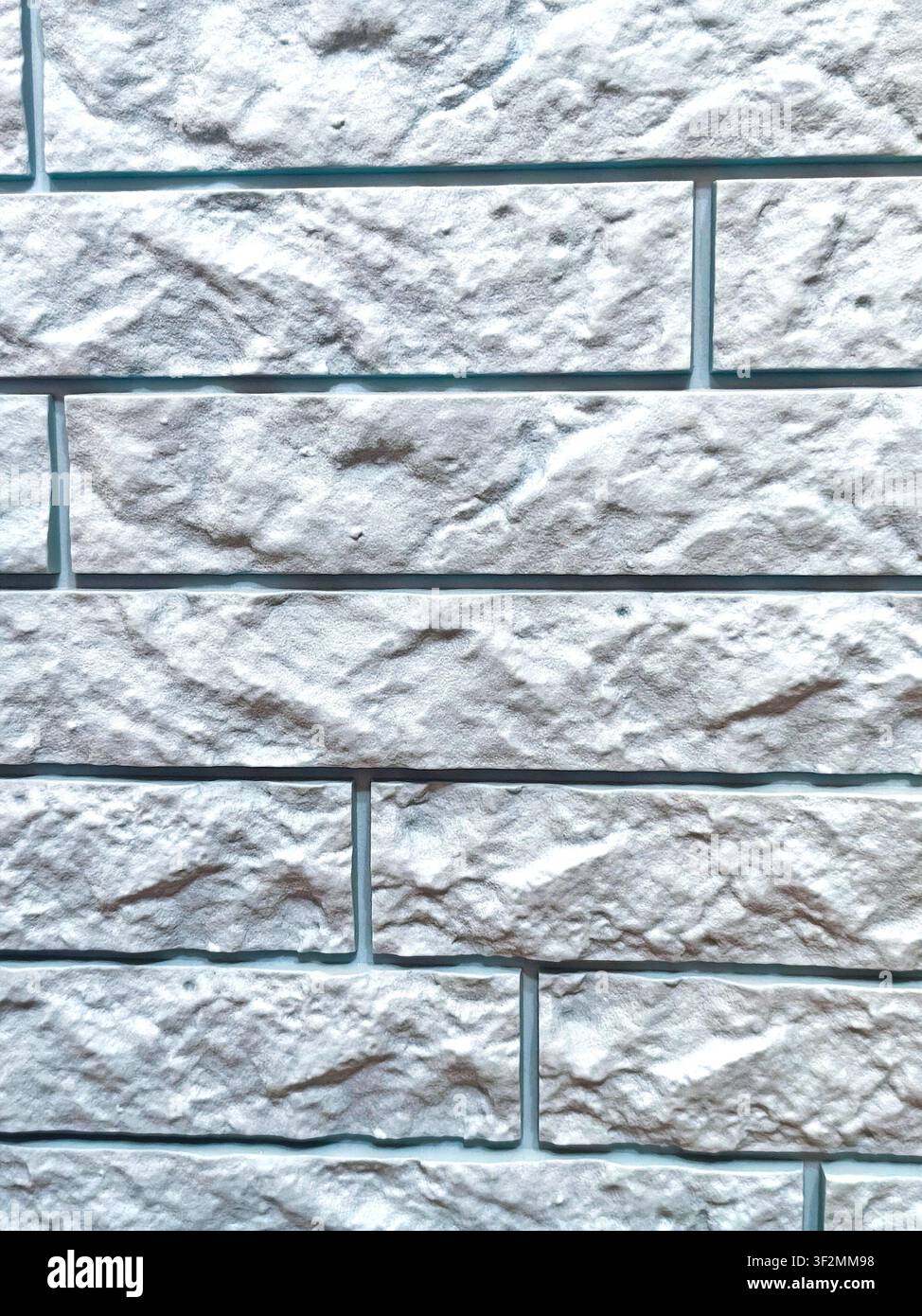 High resolution close-up of a white decorative stone brick wall with realistic rough texture and horizontal masonry pattern. Ideal seamless background Stock Photo