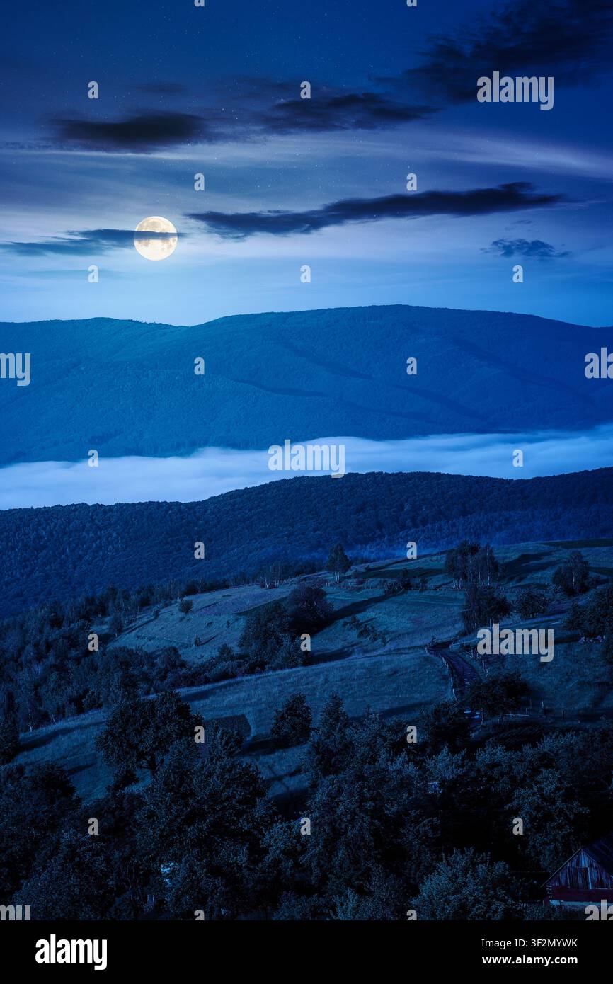 carpathian mountain landscape on a foggy night. outdoor adventure with stunning view. full moon over mountainous countryside of ukraine in summer. mys Stock Photo