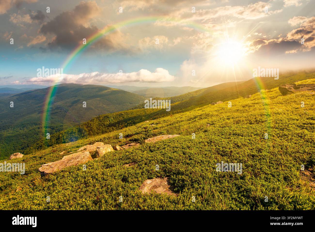 sunset over nature scenery with mountain under summer sky. alpine landscape of carpathian mountain with grassy slopes. low fluffy clouds on high altit Stock Photo