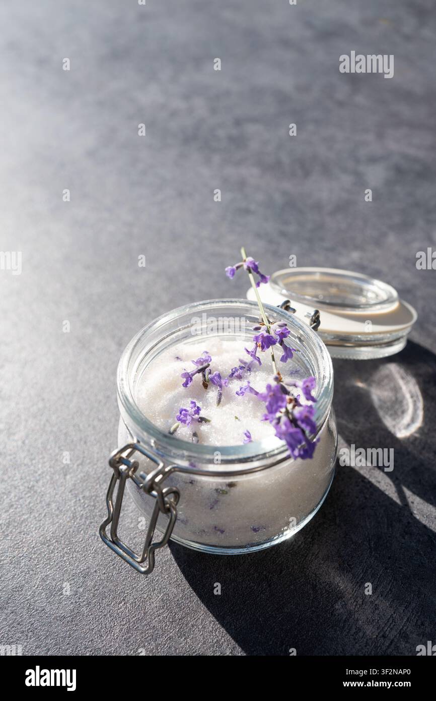Lavender sugar in glass jar with fresh lavender on gray background Stock Photo