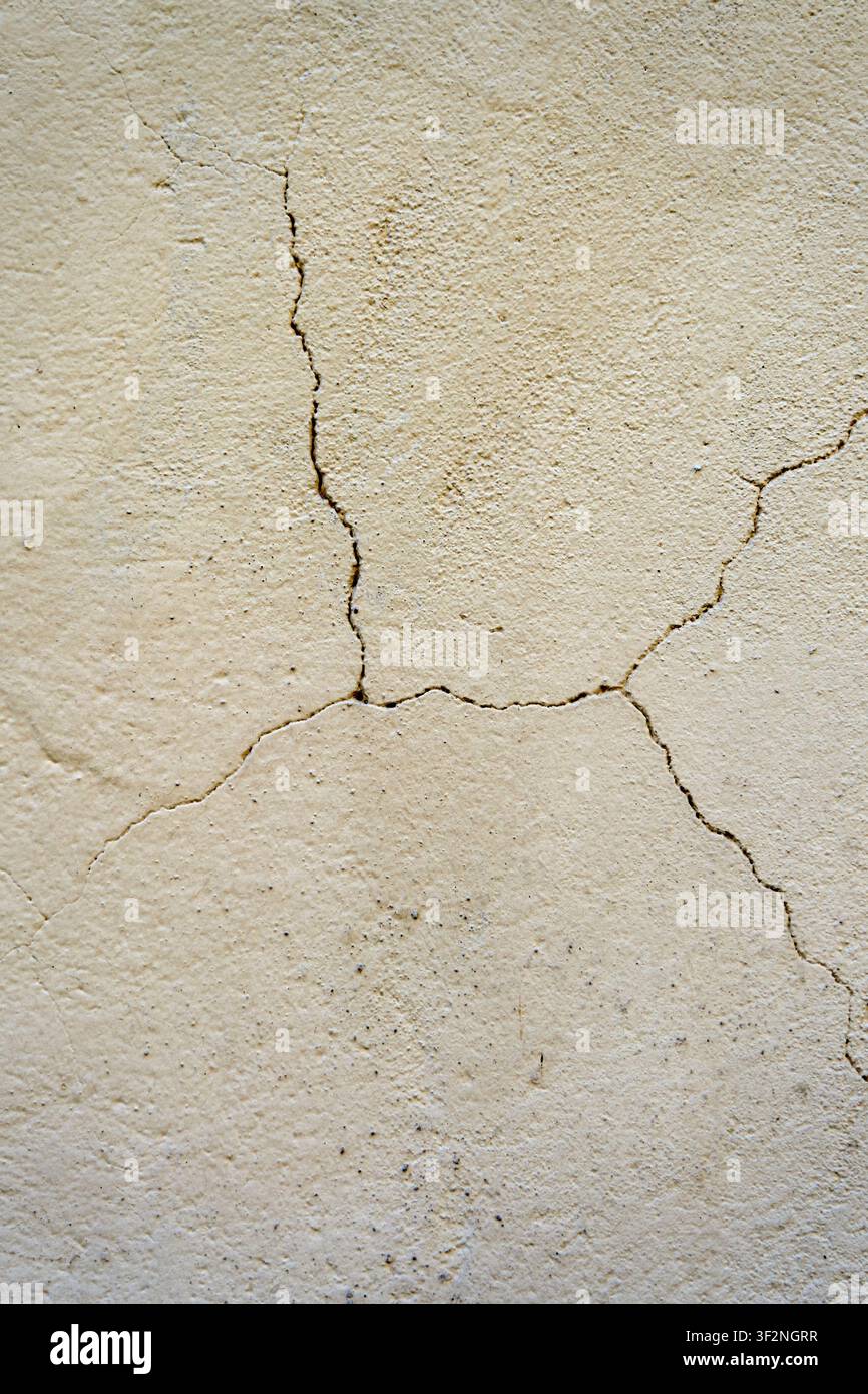 Weathered Beige Plaster Wall Texture with Natural Crack Pattern and Distressed Surface Background. Stock Photo