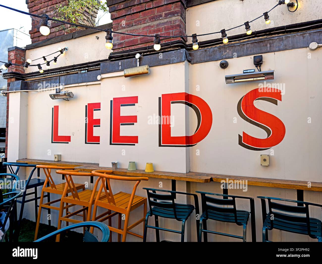 Large red LEEDS lettering and colourful outdoor seating on the private terrace at The Brewery Tap in Leeds, West Yorkshire, England, UK Stock Photo